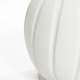 Close-up of a white textured ceramic vase with a minimalist design, featuring vertical ribbed patterns and showcasing a smooth, curved surface.