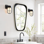 Modern bathroom with an elongated mirror, black fixtures, and two wall lights. A plant sits on the marble counter by the sink, while a window reflects the greenery outside, adding a contemporary touch to this serene space.