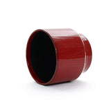 A burgundy red glazed round ceramic planter by LuxenHome, standing 10.83 inches tall, lies on its side against a plain white background, showcasing a sleek design with a smooth surface and subtle vertical stripes for elegance.