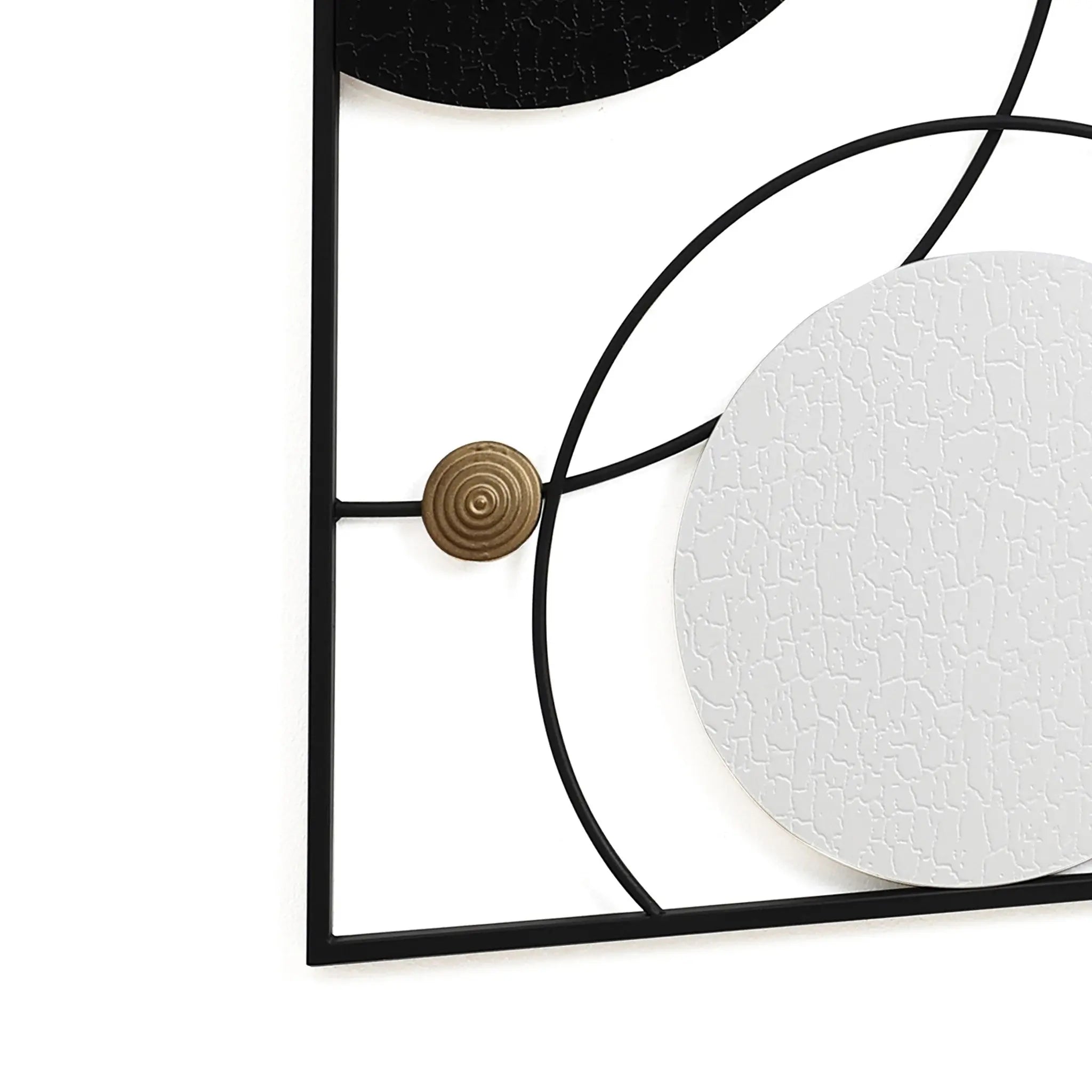 Modern abstract wall decor featuring intersecting black and white circles with textured surfaces, complemented by a small bronze circular detail and encased in a minimalist black frame.