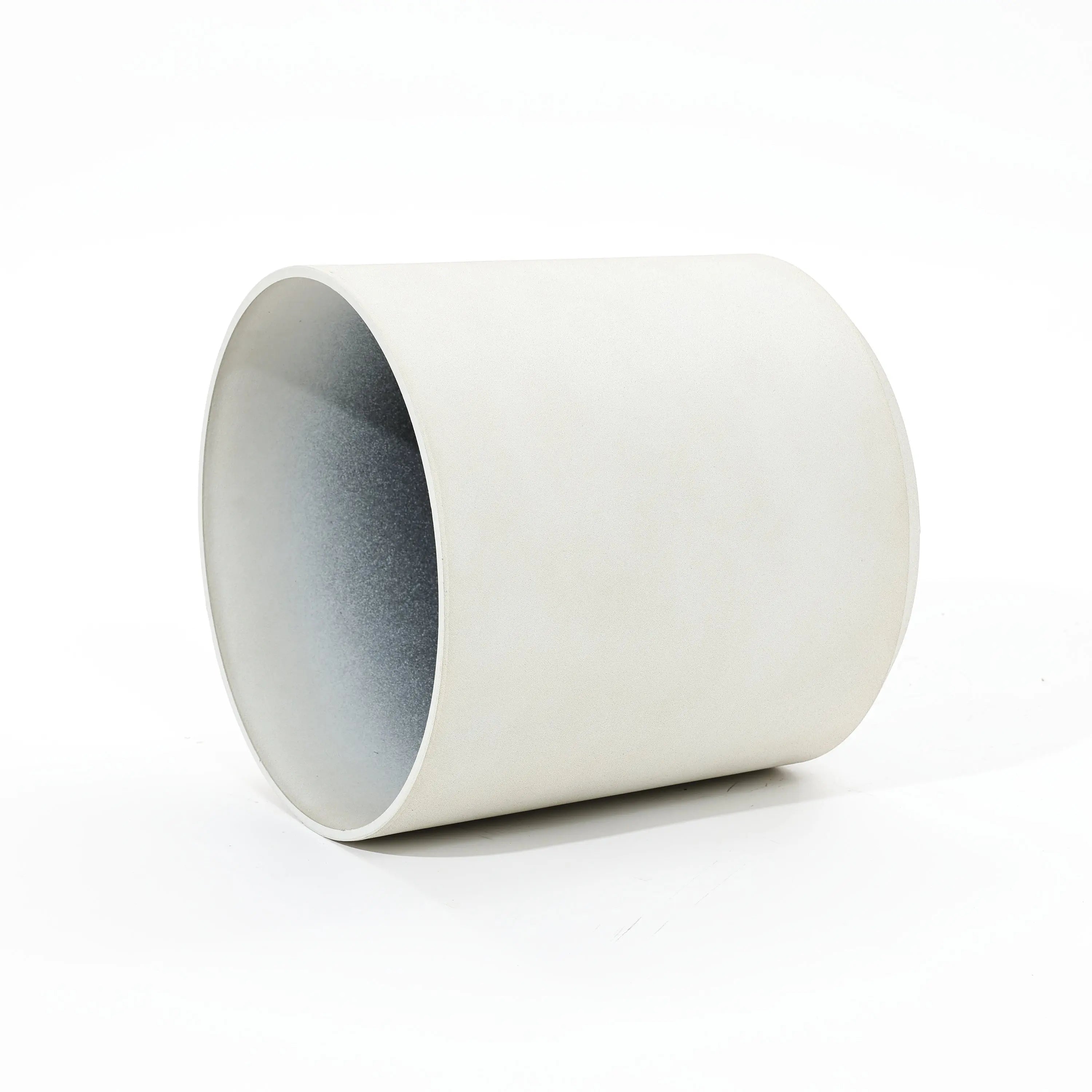 A contemporary, durable white ceramic planter lies on its side against a plain background, showcasing its sleek cylindrical design.