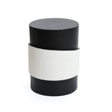 A cylindrical black object with a unique white irregular pattern wrapped around the middle, set against a plain white background.