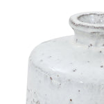 Close-up of the upper part of a white stoneware vase with a textured surface and a narrow, bottle-like neck.