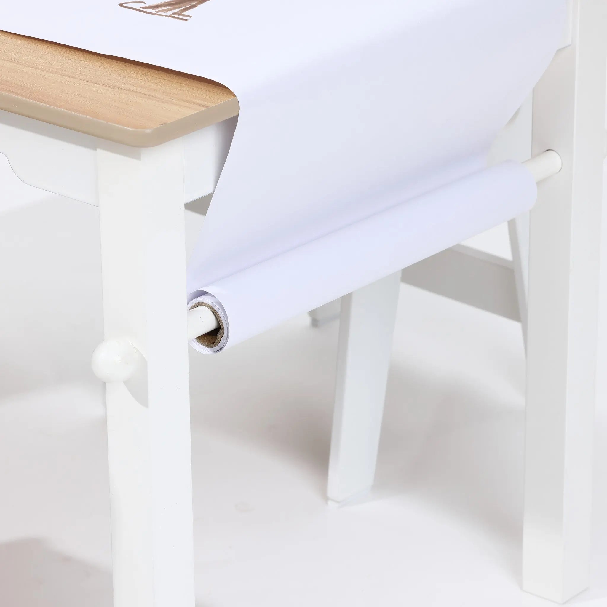 The LuxenHome Children Play Table with Bookcase and 2 Chairs Set includes a white arts and crafts table with a wooden top and a roll of white paper mounted underneath, unrolling onto the surface for crafting or drawing.