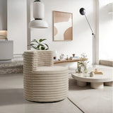 A modern living room showcases a LuxenHome Brie camel swivel barrel accent chair, a round coffee table with decor, and a minimalist floor lamp. A potted plant adds greenery while abstract art adorns the wall. Soft, neutral tones create an inviting atmosphere.