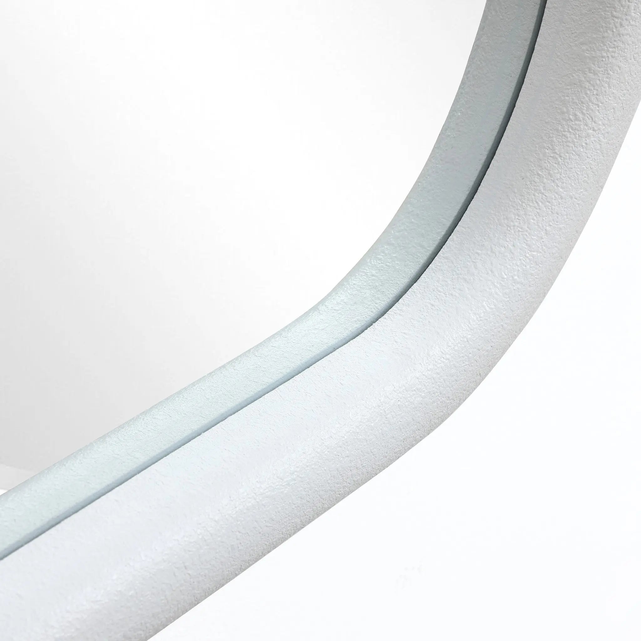 Close-up of a curved, light grey, textured surface with a C-shaped silhouette, possibly part of a modern architectural structure or furniture piece, set against a white background.