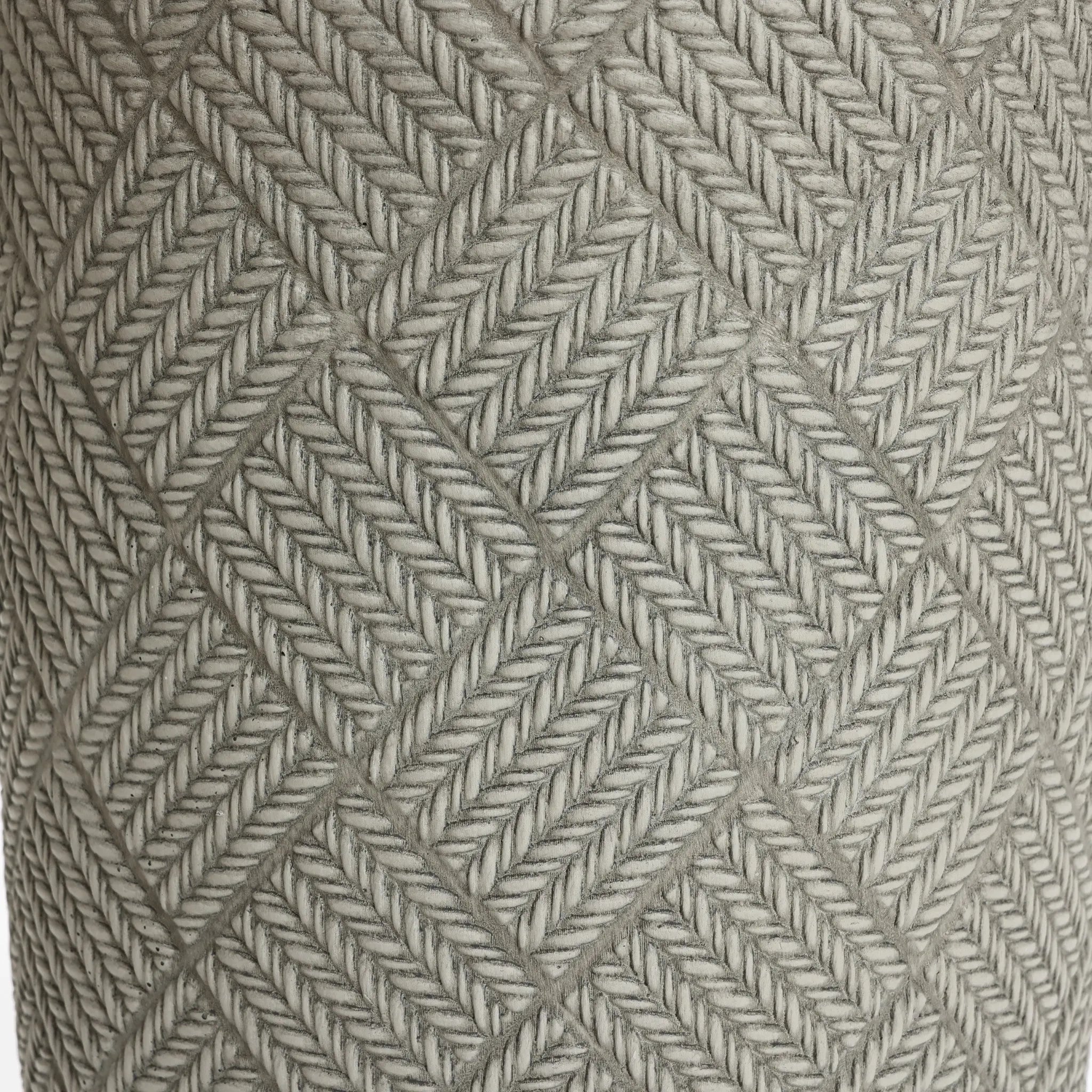 Close-up of a textured surface featuring a pattern of interwoven diamond shapes formed by intricately braided grey rope, reminiscent of the sleek lines found in modern minimalist design.