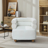 A cozy living room showcases the LuxenHome Tia ivory barrel accent chair with a double bolster backrest and rounded armrests on wooden ball legs, accompanied by a wooden cabinet, decorative vase, painting, books, and a round coffee table on a patterned rug.