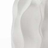 Close-up of a white, wavy-textured surface, resembling abstract flowing shapes or smooth fabric folds, echoing the elegant design of a ceramic vase.