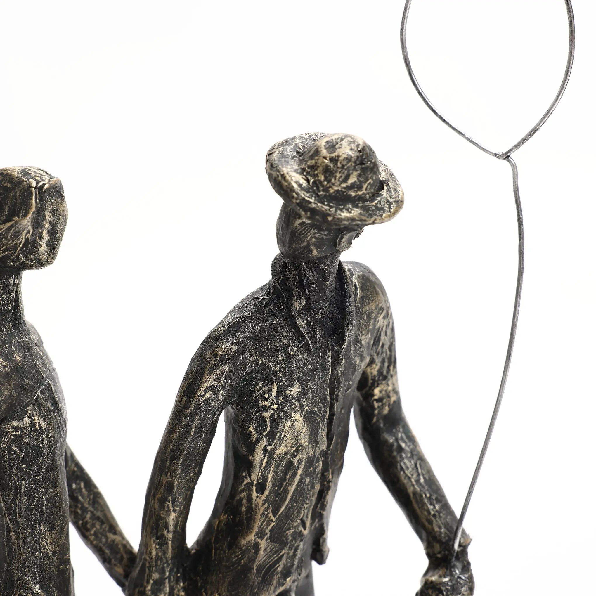 A textured sculpture of two figures, crafted from modern resin, features one holding a balloon. The figures appear to be wearing hats and walking together, making it a charming home decoration.