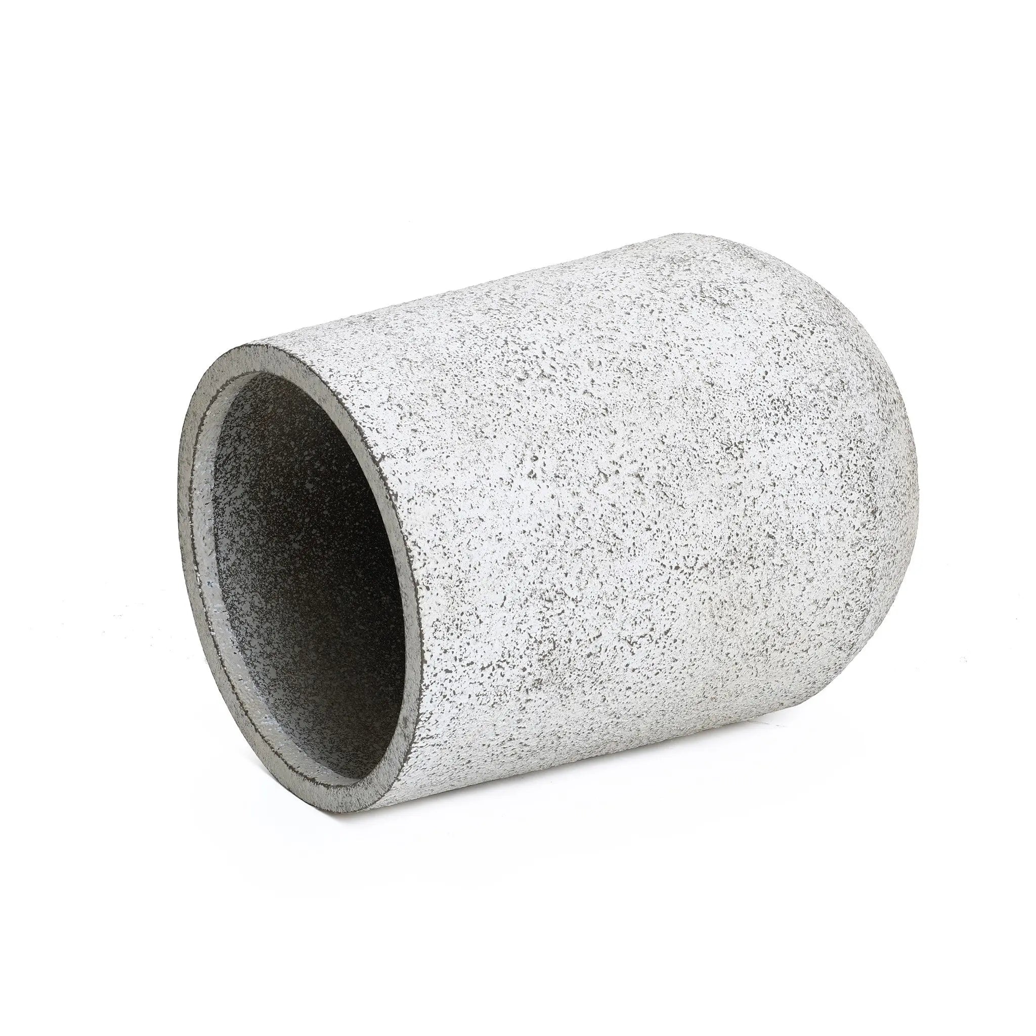 A concrete cylinder with a gray and white speckled texture lies on its side against a plain white background, showcasing a modern design.