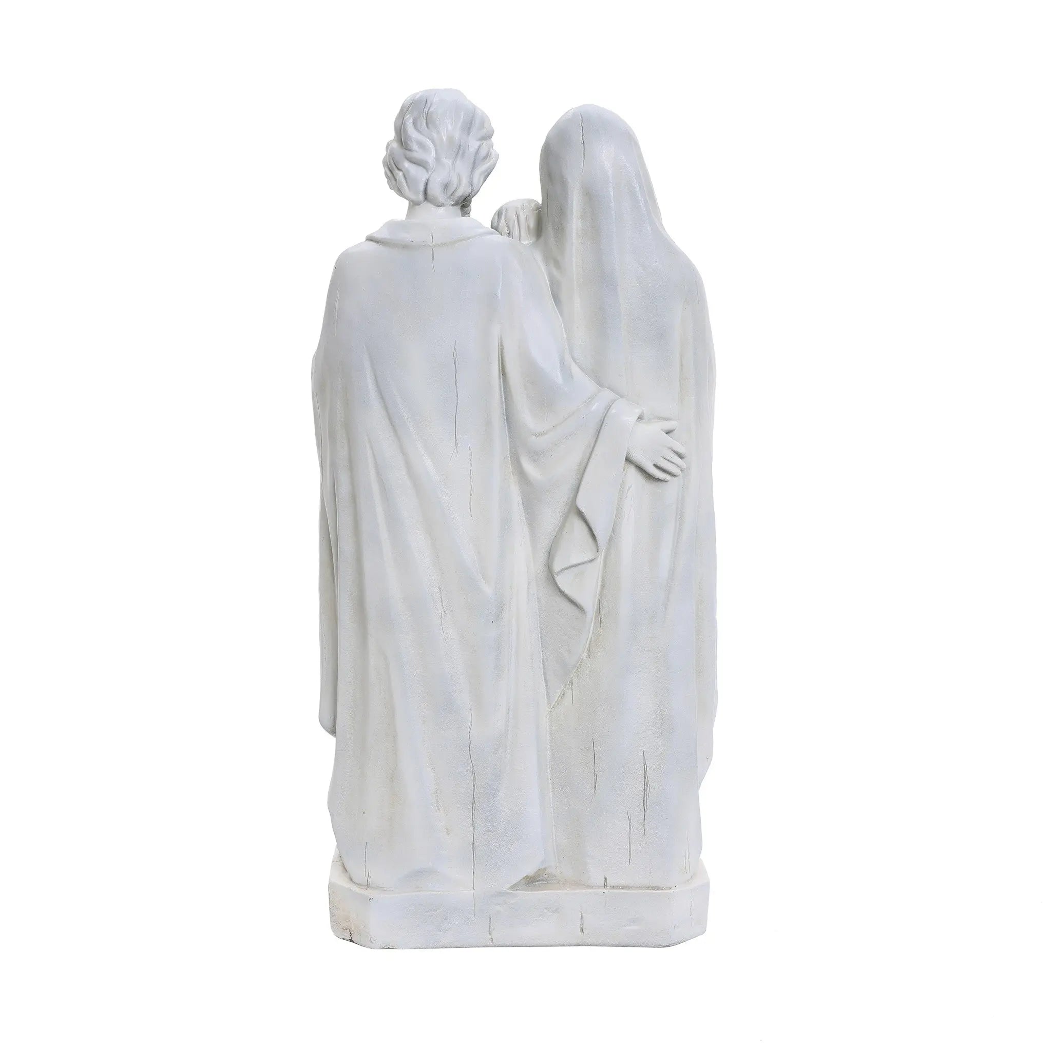 Back view of two white marble statues, reminiscent of a Holy Family statue, standing side by side with one gently draping an arm around the other. Both cloaked in elegantly flowing robes, this piece captures the essence of religious decor in a serene display.