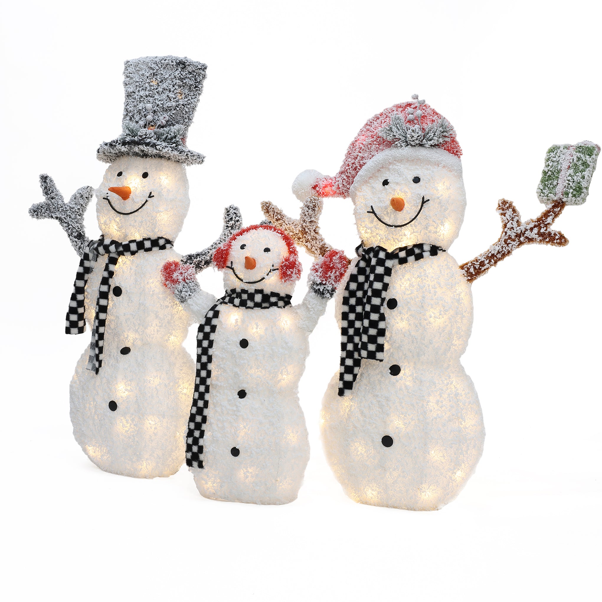 Three lighted snowman decorations with plaid scarves and hats, two adults and one child, all smiling and waving—one holds a green gift box. The perfect outdoor Christmas decor for a festive touch to your yard.