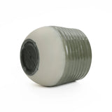 A ribbed, cylindrical planter with a smooth, light-colored base is shown from a low angle against a plain white background. Designed for indoor and outdoor environments, it blends functionality with style effortlessly.