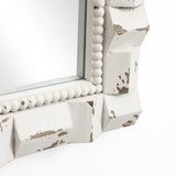 This arched rectangular mirror features a close-up of its corner, showcasing a distressed white wooden frame with ornate bead detailing, perfect for adding a touch of vintage charm to any home decoration.