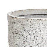 Close-up of an antique charm planter with a textured, light-gray concrete surface and a round, open top, showcasing its rough, speckled finish.