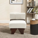 The Lorenzo boucle upholstered wood frame armless accent chair by LuxenHome, featuring a fluffy white cushion and dark wooden legs, adds mid-century allure to the cozy room. Nearby sits a round table with decor, a bookshelf of books and items, and a picture frame on the light-colored wall.