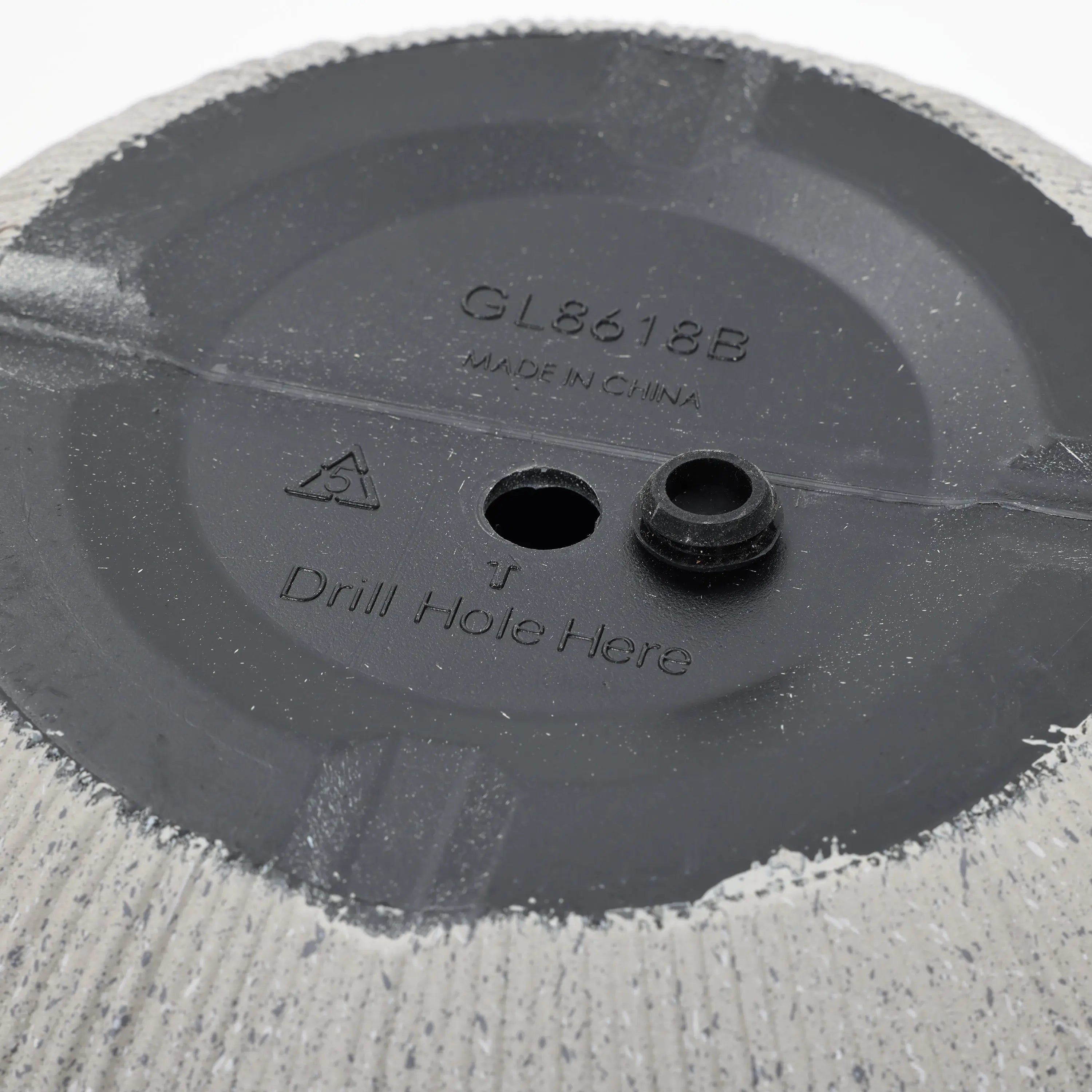 Bottom of a textured planter featuring a modern striped pattern and a marked location to drill a hole, along with the text GL8618B Made in China. Perfect for enhancing your home and garden aesthetic.