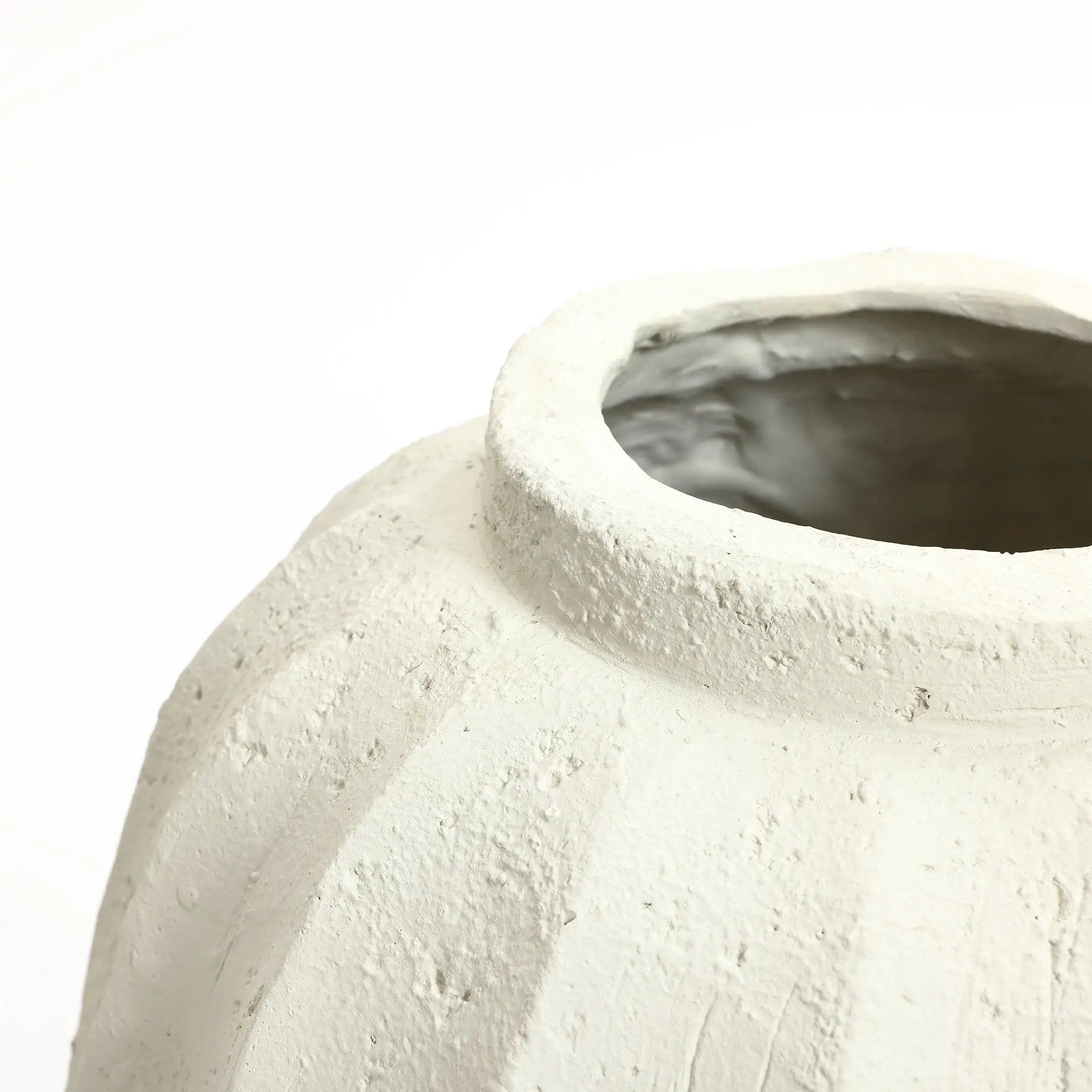 Close-up of a textured, unglazed ceramic pot with a wide opening, serving as an artistic centerpiece against a plain white background. Ideal for those seeking minimalist home decor to enhance their space.