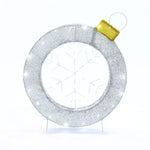 A circular silver ornament with a gold cap, featuring a snowflake design in the center, captures the essence of holiday decoration against a plain white background.