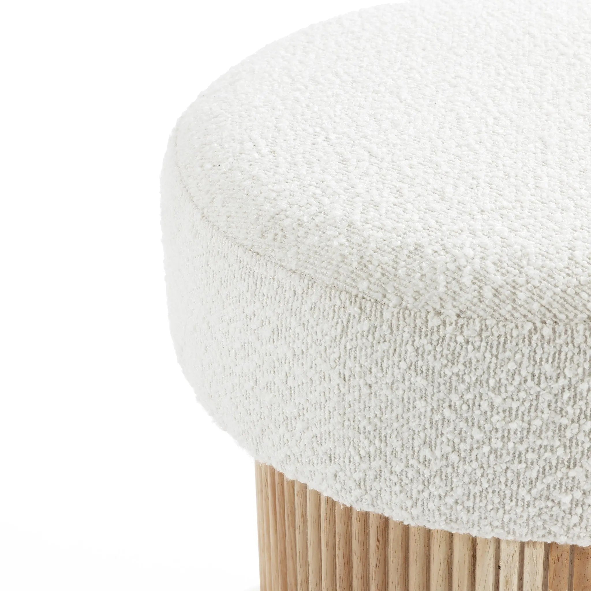 Close-up image of the elegant LuxenHome Mina boucle and wood storage ottoman featuring a round, textured white fabric cushion atop vertically aligned light wooden legs, combining soft plush fabric with smooth polished wood to offer both style and functionality.