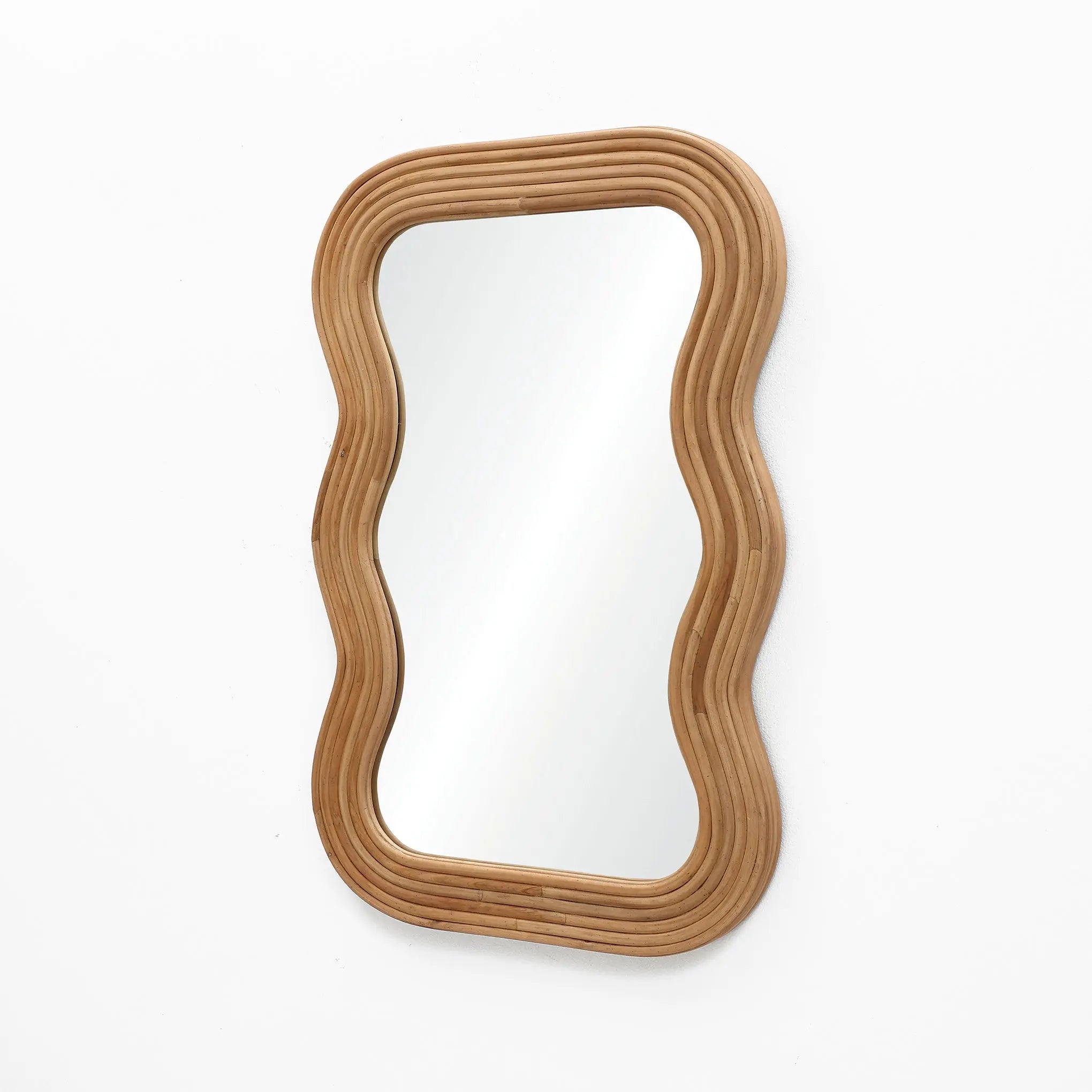 A modern vibe emanates from the wavy-edged rectangular wall mirror, its natural cork wood frame contrasting elegantly against the plain white background.