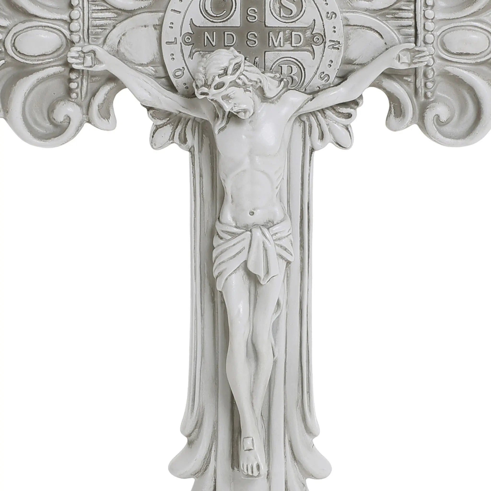 White crucifix with a detailed depiction of Jesus on the cross, emblematic of the Christian faith, featuring ornate decorations and a circular emblem with letters above. Perfect for religious occasions.