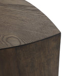 Close-up of the corner of a wooden table with a dark, textured grain and mid-century modern elegance. The edge is gently rounded.