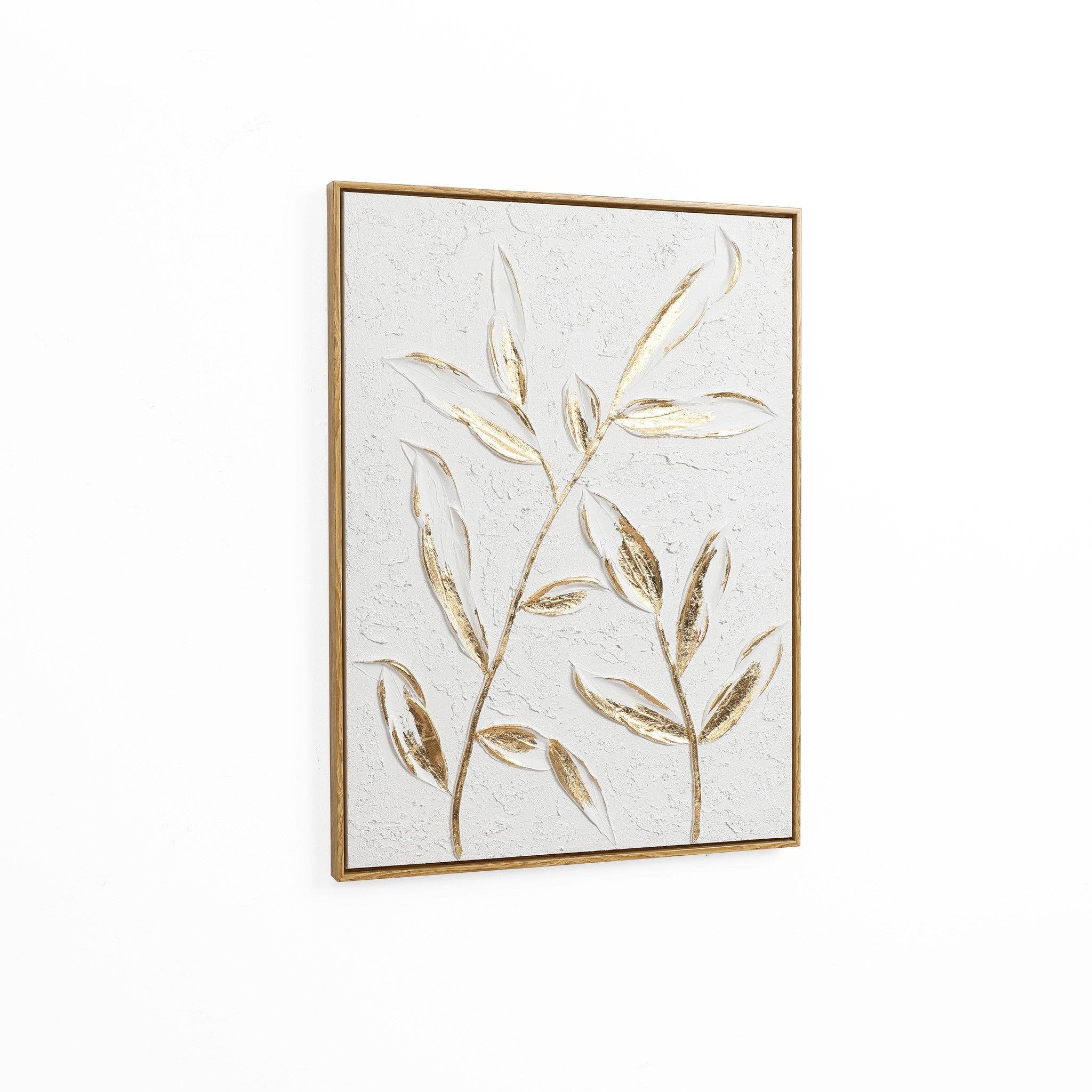 Framed artwork featuring two stylized branches with textured leaves and a subtle gold leaf motif on a neutral background, set against a plain white wall.