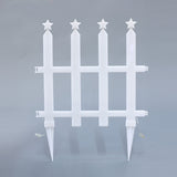 White plastic fence with 4 vertical posts, each topped with star,2 ground stakes the bottom, small electrical wires attached.
