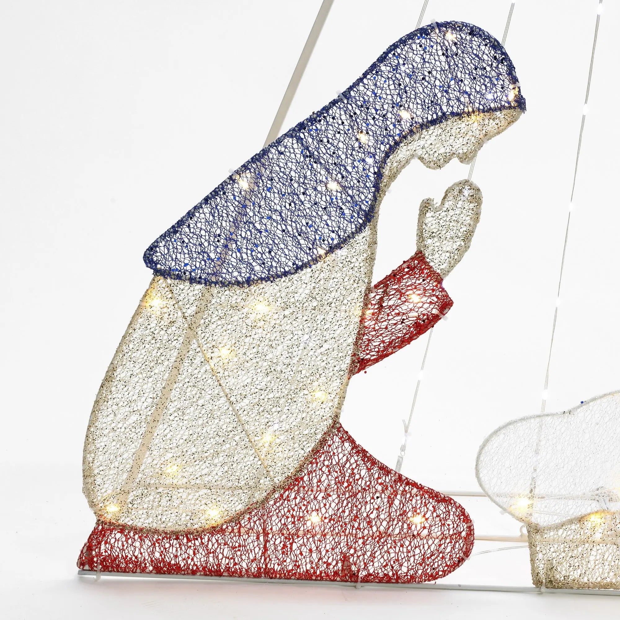 A woven light-up figure of a kneeling woman features a blue head covering, white robe, and red sleeves and skirt. Enhanced with LED bulbs to shine brightly, this enchanting Christmas decoration evokes the guiding light of the North Star.