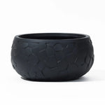 The LuxenHome Black beehive pattern round tabletop planter, 17.5 w, features a geometric beehive texture on its surface against a white backdrop, offering a durable and textured appearance.