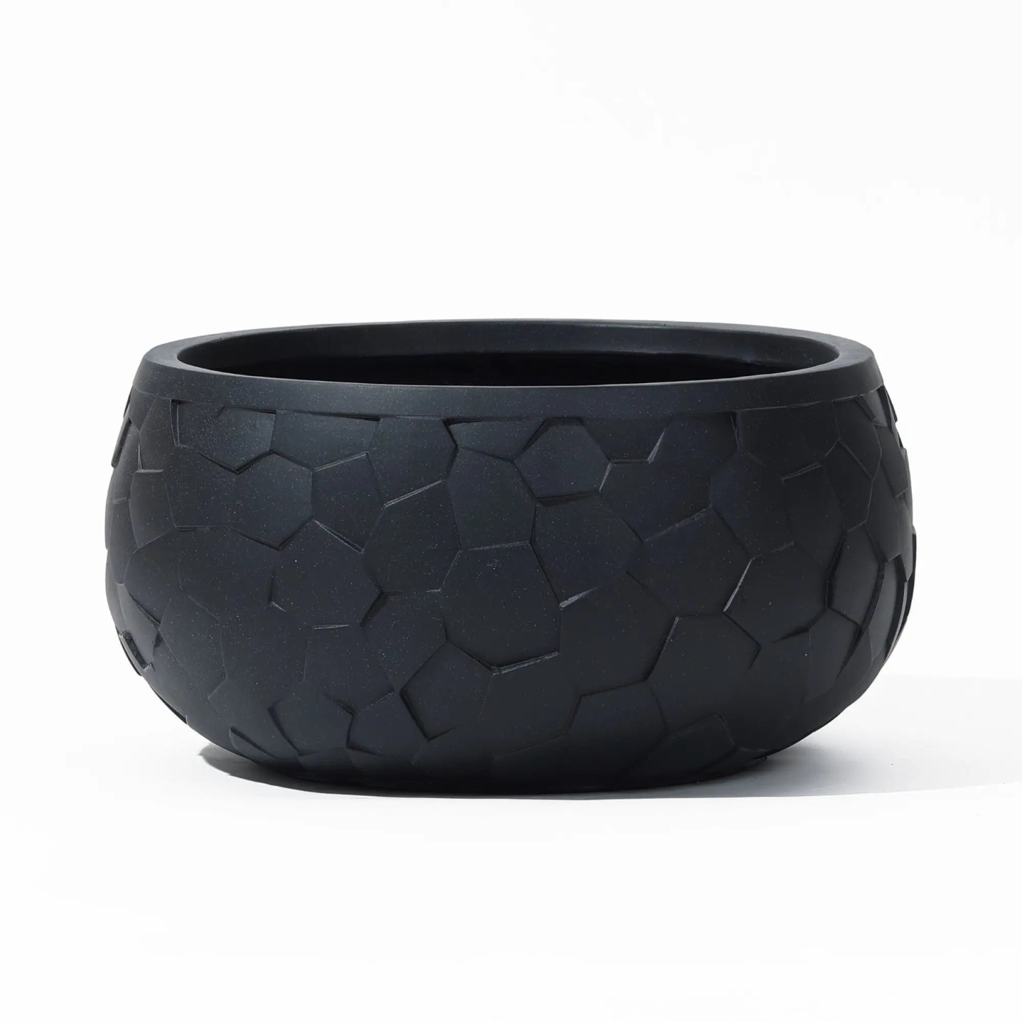 The LuxenHome Black beehive pattern round tabletop planter, 17.5 w, features a geometric beehive texture on its surface against a white backdrop, offering a durable and textured appearance.