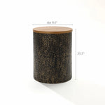 This black and gold table features a wooden top crafted from fir veneer and rests elegantly on a textured, hammered iron cylindrical base. Dimensions: 15.7 inches in diameter and 20.3 inches in height.