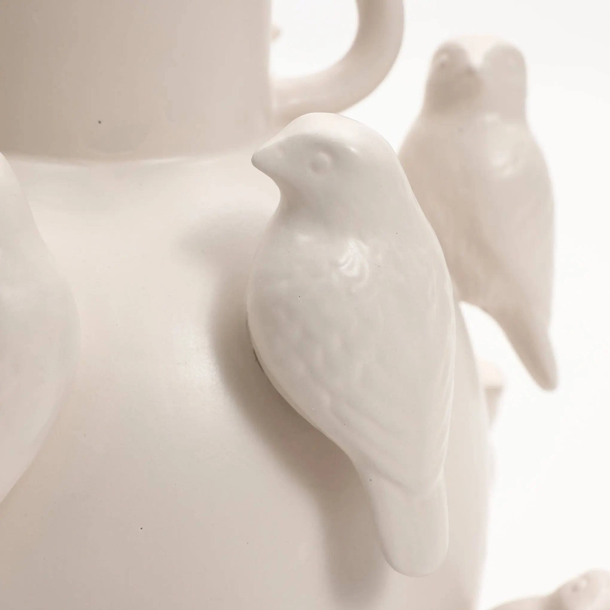 The LuxenHome White Ceramic Birds Vase, standing at 14.4 inches, features sculpted birds with intricately detailed feathers. Its monochromatic design adds an elegant and artistic touch to modern home decor.