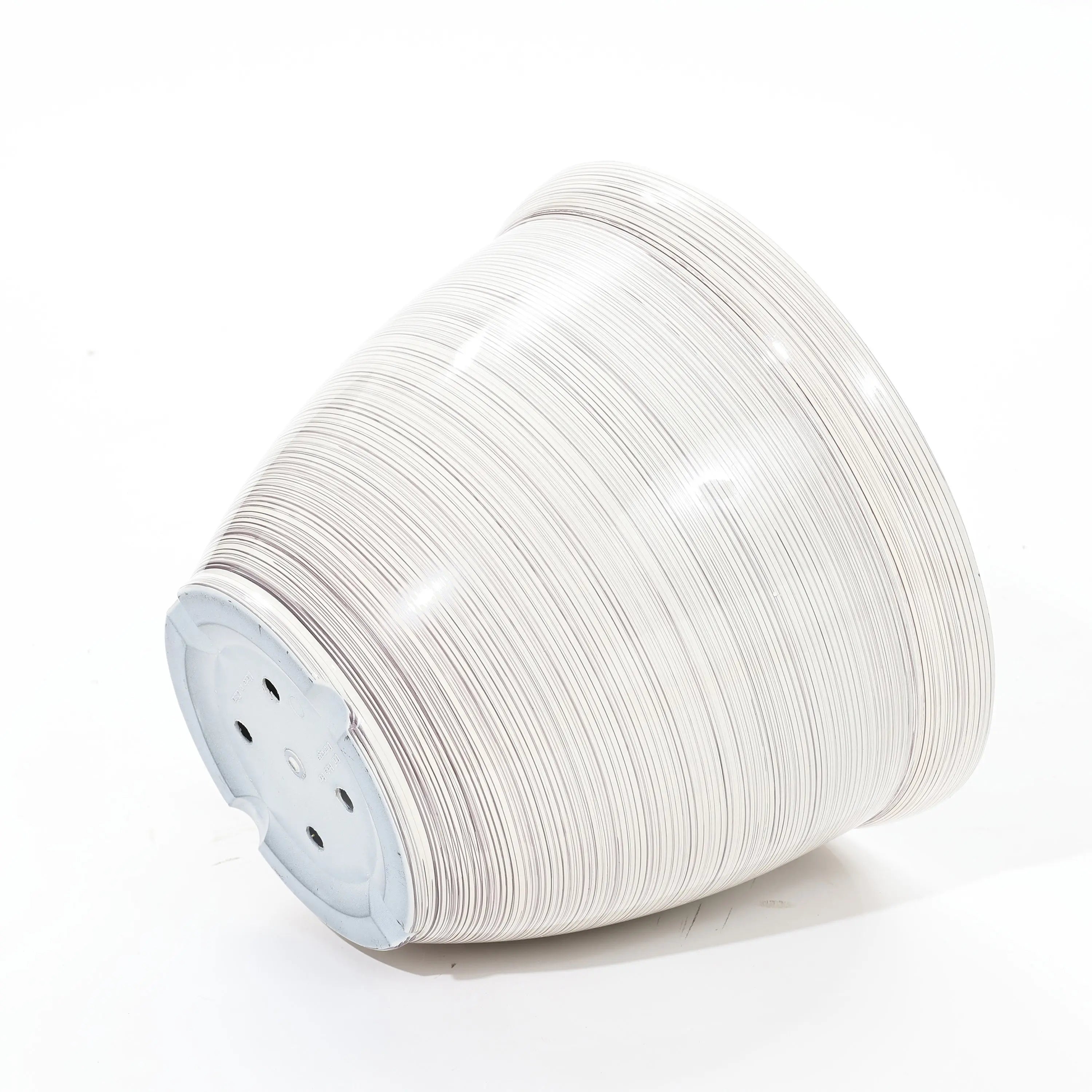 A stack of sleek, white disposable paper plates on a minimalist white background, viewed from the side, reminiscent of a contemporary planter design.
