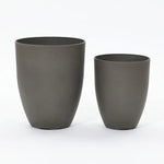 A modern planter set featuring two dark gray, cylindrical planters of different sizes is elegantly placed side by side against a plain white background.