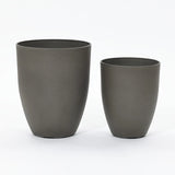 A modern planter set featuring two dark gray, cylindrical planters of different sizes is elegantly placed side by side against a plain white background.