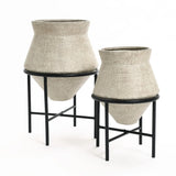 Two beige, textured cachepot planters on black metal stands, one larger than the other, add a touch of vintage distressed style against a white background. Perfect for elevating your indoor space decor with elegance and charm.