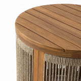 Round drum-shaped end table made of natural acacia wood, featuring a slatted top and hand-woven rope-wrapped sides, viewed from above at a slight angle.