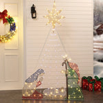 A light-up nativity scene with Mary, Joseph, and baby Jesus beneath an LED bulb designed to resemble the North Star, set against a white wall. Festive wreaths and presents complete this charming Christmas decoration.