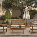 Outdoor patio featuring an outdoor loveseat set crafted from FSC-certified Acacia wood, accompanied by chairs, a sofa, and a table. A closed umbrella shades potted plants and a large tree in the background on a stone surface.