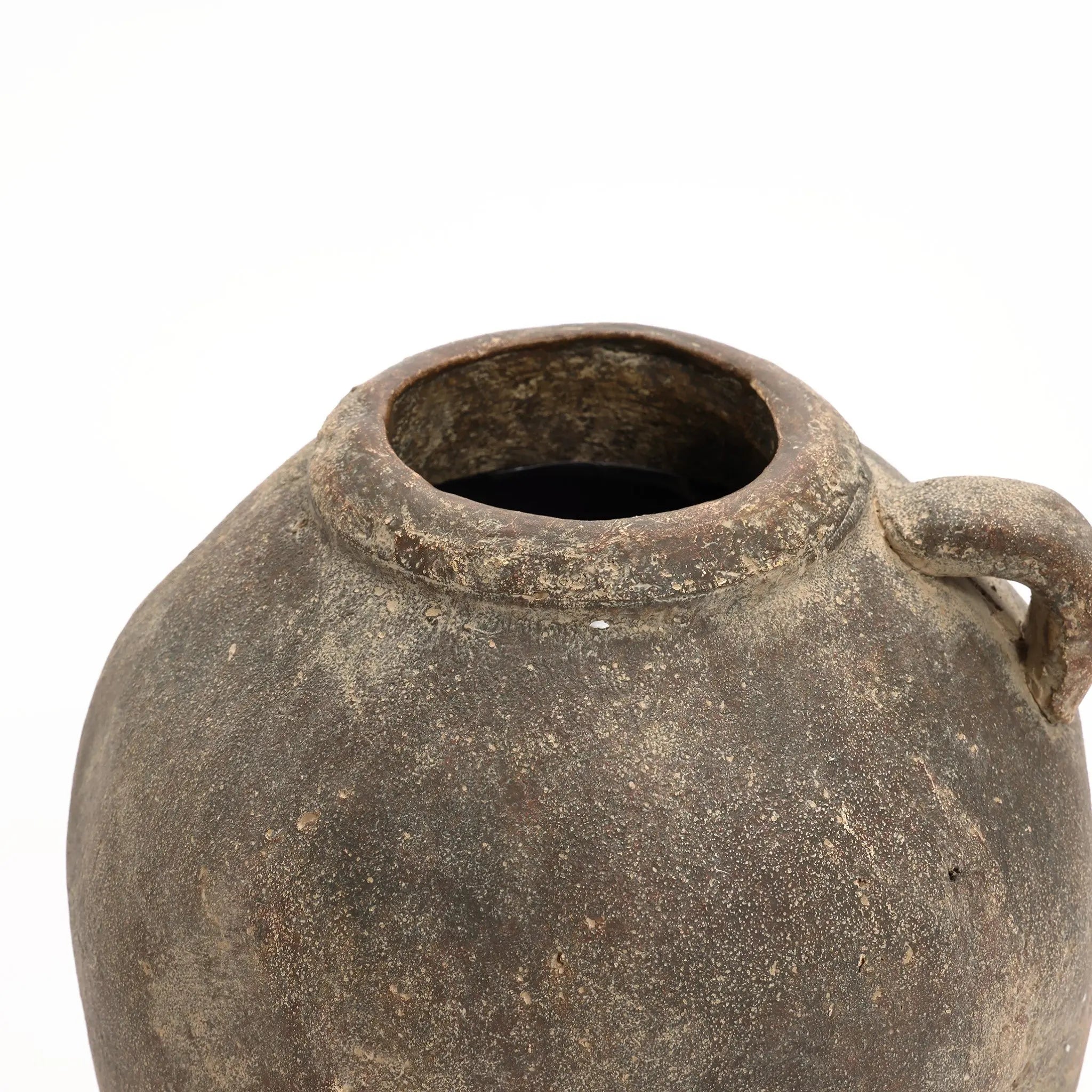 A rustic terracotta vase with a weathered, round shape features a wide opening and a small handle on one side, perfect for both indoor and outdoor use. Its handcrafted weathered finish stands out against the plain white background, offering timeless charm.
