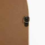 Close-up of a brass-colored metal picture frame hanger on the back of a wooden frame, resembling the elegant touch youd find in a bamboo-framed mirror. Set against a white background, it evokes the charm of a decorative hanging mirror with an arched rectangular design.