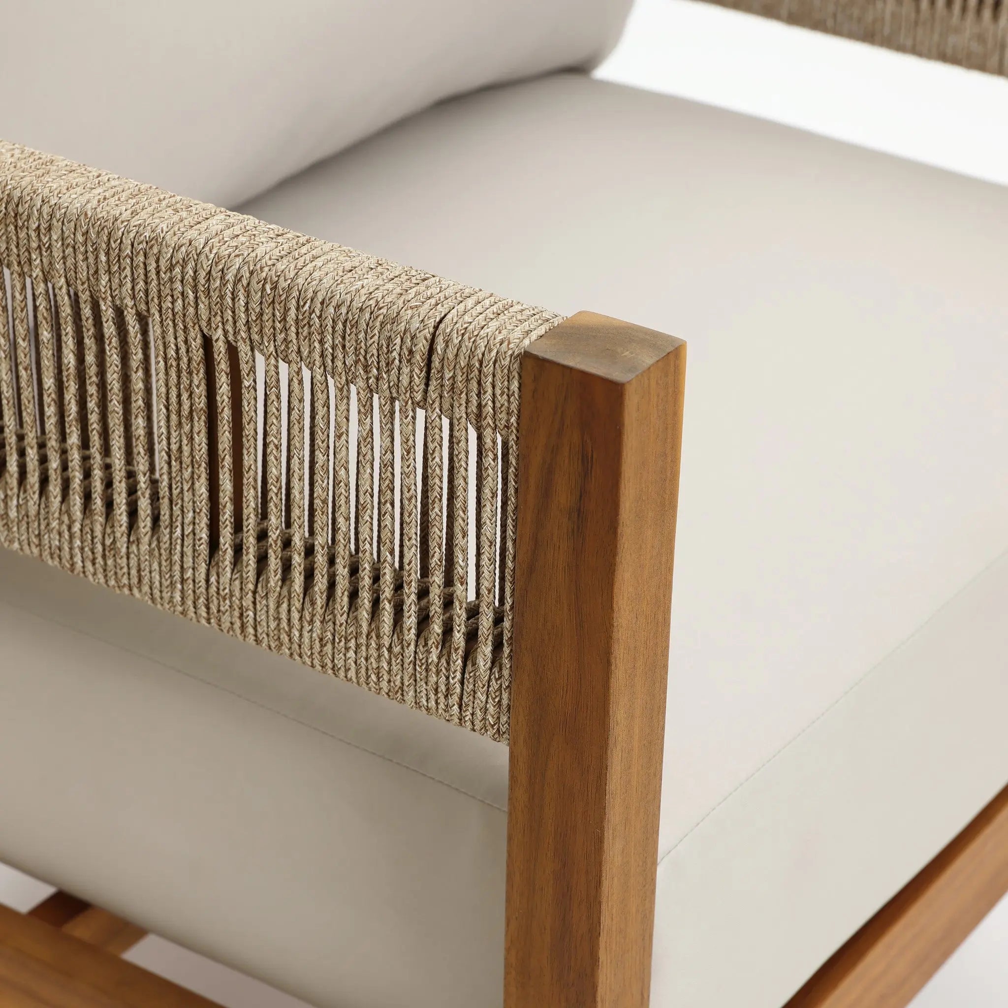 Close-up of a modern armchair featuring Outdoor Acacia Wood frame, rope-wrapped armrest, and light-colored cushioned seat and backrest—perfect for club-style patio furniture ensembles.