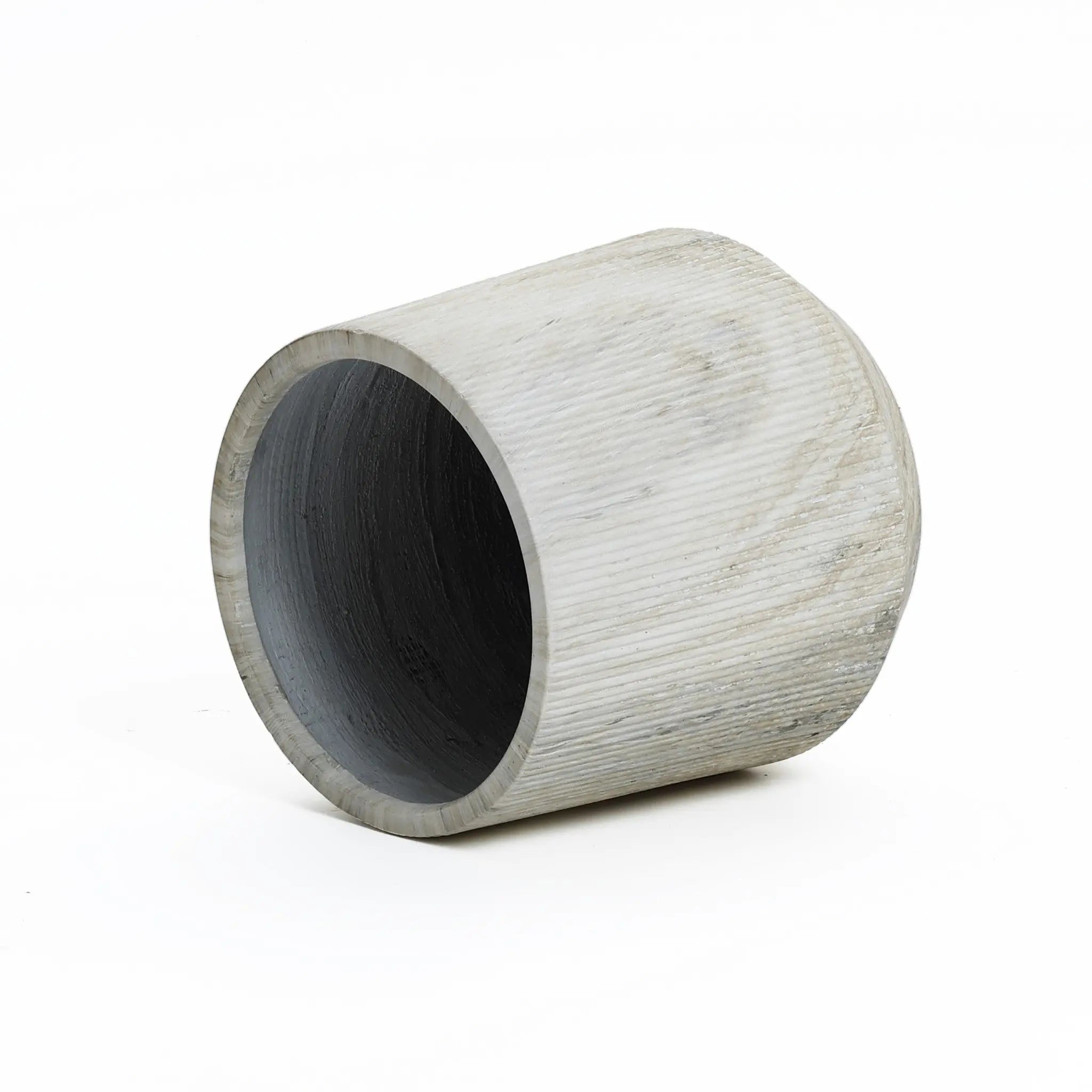 A gray, cylindrical concrete planter with a subtle marble ribbed texture lies on its side against a white background.