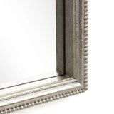 Close-up of a picture frame corner with a beaded edge and metallic finish, exuding a modern romantic style reminiscent of an arched silhouette.