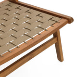 Close-up of a woven chair with a beige seat made from interlaced straps. Crafted from acacia wood, this simple, angled piece boasts a natural finish, making it ideal for outdoor furniture settings.