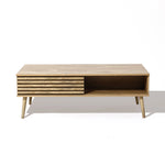 Wooden coffee table with angled legs, featuring sliding doors and a slatted front panel that reveals dual-side storage. Perfectly displayed on a white background, it offers both style and functionality.