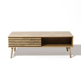 Wooden coffee table with angled legs, featuring sliding doors and a slatted front panel that reveals dual-side storage. Perfectly displayed on a white background, it offers both style and functionality.